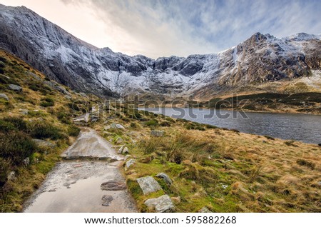Llyn Idwal lake lying within Cwm Idwal in the Glyderau mountains of Snowdonia, Wales, UK. Snow covered peaks on a cold winter evening