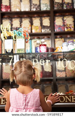 Excited Girl Standing In Sweet Shop Royalty-Free Stock Photo #59589817
