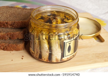 Fish sprats canned food in oil in a glass jar Royalty-Free Stock Photo #595914740