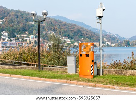 Pavement mounted Speed control device hidden inside the orange box, situated in urban areas of Italy.