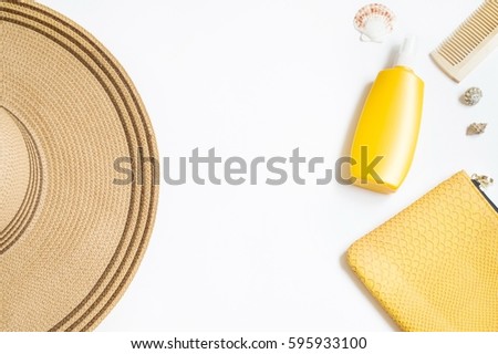 Straw hat, yellow bottle with sunscreen, wooden comb, cosmetic bag and seashells. Mockup for design with free space for text. Beach accessories. Summer rest concept. Flat lay photography, top view