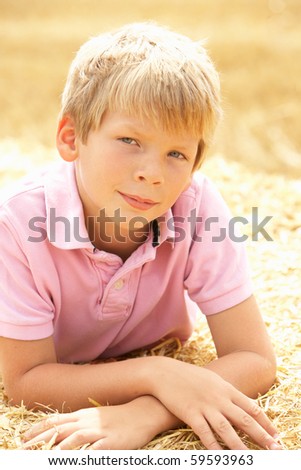 Portrait Of Boy Laying In Summer Harvested Field