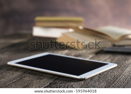 Rustic wooden desk with tablet, books, pen, clock, place for typography and logo
