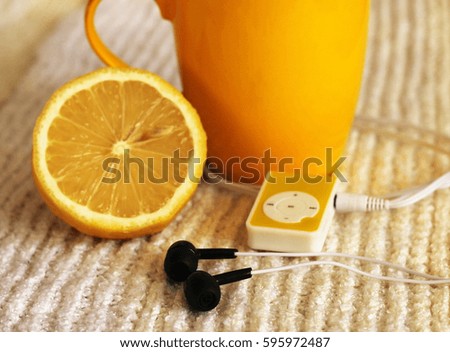 Yellow mug and mp3 player and lemon
