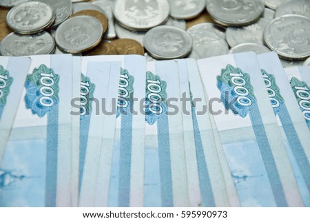 one-thousand rubles banknotes on the coins background