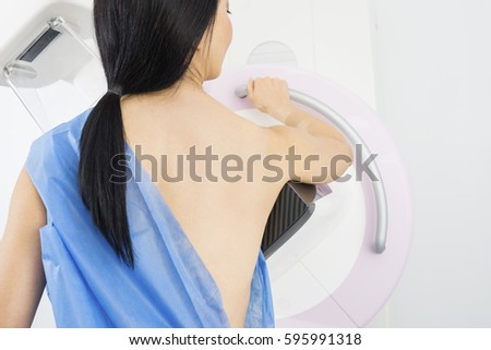 Woman Standing In Front Of Mammography Machine Royalty-Free Stock Photo #595991318