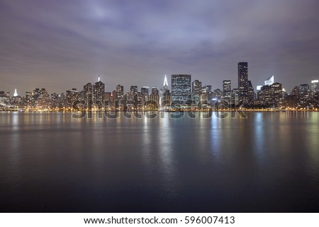 Mid Town Manhattan illuminated at night from Gantry Plaza State Park with East River