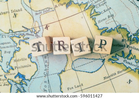 Trip word made from wooden letter blocks on a vintage map. Travel, holiday concept