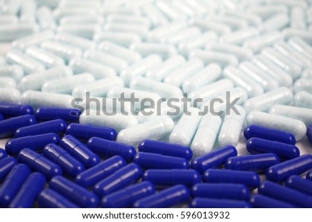 Many pills and tablets in blue and white color. Pharmacy medical background. Close up of a lot of drugs. Pharmacological industry topic.