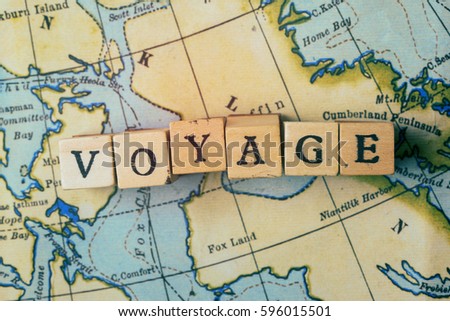 Voyage word made from wooden letter blocks on a vintage map. Travel, holiday concept