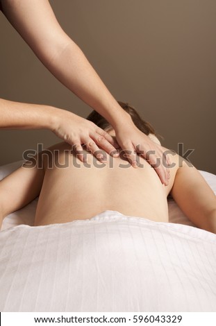 Massage therapy theme photo. A female massage therapist massaging a female client.