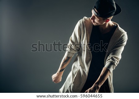 Young and stylish modern dancer on grey background