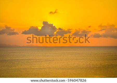 perfect sun hides behind clowds dramatic and colorful sunset at beach