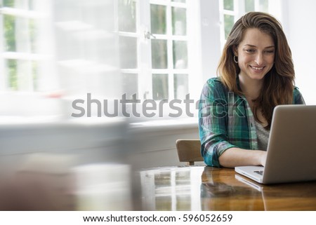 Smiling woman with laptop in home office