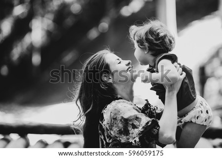 Happy mother holds charming little girl in her hands Royalty-Free Stock Photo #596059175