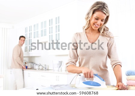 Happy young beautiful woman ironing clothes. Housework