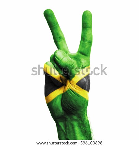 Jamaica national flag painted onto a male hand showing a V peace sign