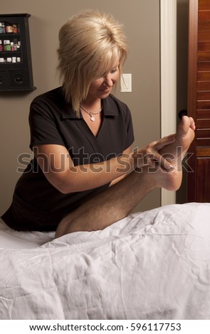 Massage therapy theme photo. Female massage therapist massaging a male client.