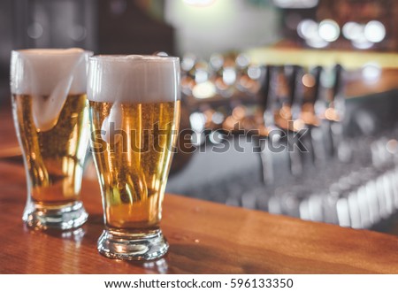 Two  Glasses of Beer on a bar table. Closeup. Royalty-Free Stock Photo #596133350