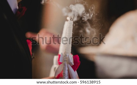 The charming brides keeping candles in the church