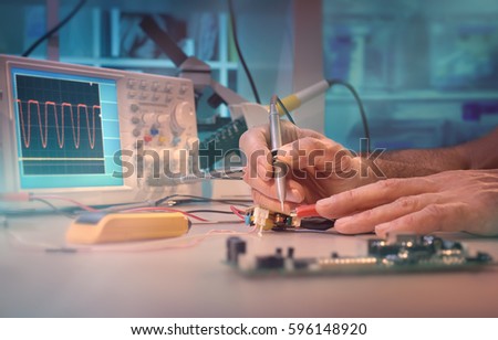 Hands of a senior male engineer testing electronic equipment in hardware service center. This picture is toned. Space for your text.