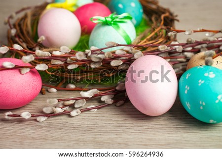 Easter composition of the branches, cakes, tulips colored eggs cooked for the holiday on the wooden background