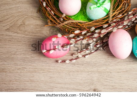 Easter composition of the branches, cakes, tulips colored eggs cooked for the holiday on the wooden background