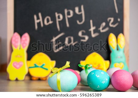 Easter composition of colored eggs, the Easter Bunny and the inscription "Happy Easter"