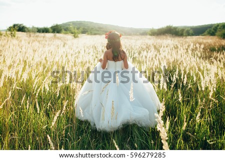 bride in a beautiful long dress posing in the garden.