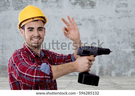 builder with the drill and the sign of approval, okay