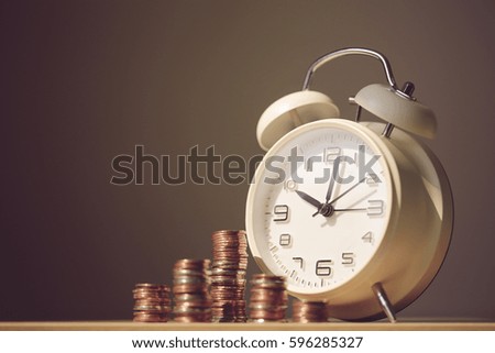 Close up shot of clock and coins with blank background. Business Finance and Money concept,Time is money. Vintage process style.