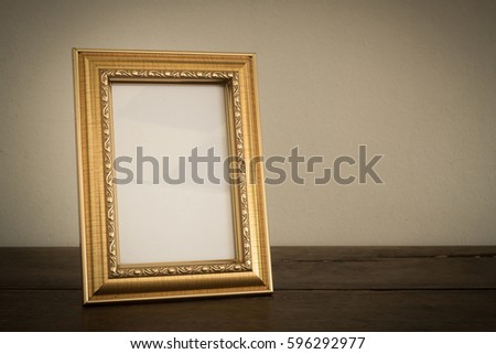 Gold photo frame on wooden