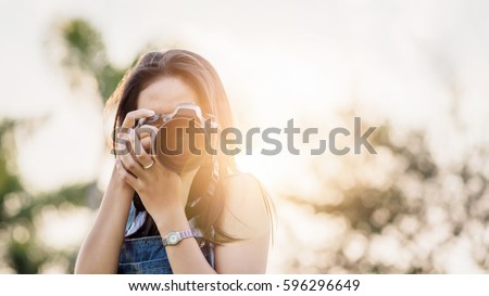 Young Asian woman photographer. Royalty-Free Stock Photo #596296649