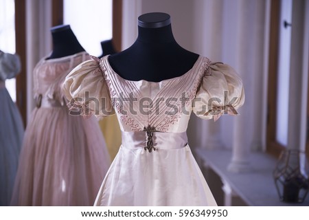 Vintage Antique Silk Dress on tailors mannequin. Pink female fashion costume details and luxury retro clothes. Elegant style. Dummy old antique wedding dress. Antique Bust wearing silk brocade corset Royalty-Free Stock Photo #596349950