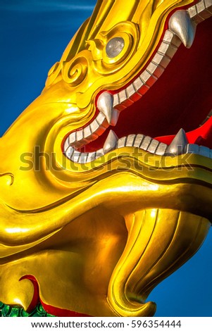 Biggest Magnificent statue Green and shiny  gold Naga , Fairy tail animal in asia religion at navy blue sky.