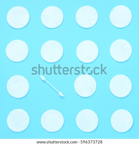 Pattern of cotton swabs and cotton pad. Hygiene, body care. Flat lay minimal concept on a blue background.Top view.