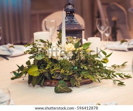 Wedding desktop decorative composition of green bouquet, candles and a candlestick