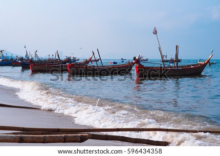four red fishing boat decorated with flags floating on the blue sea on sunny day 
