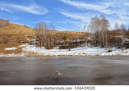 An ice-covered lake in the early spring in the Altai.