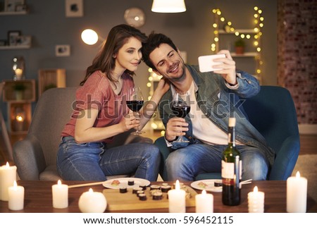 Joyful couple sitting at dining table 
