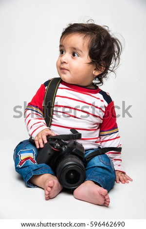 Indian cute little baby /infant or toddler holding DSLR camera, want to be a photographer