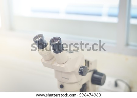 blurred stereo microscope in biology laboratory in white