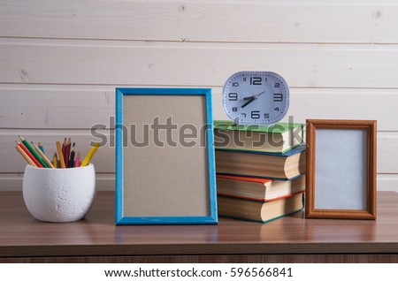  frame and pile of old books on wooden table