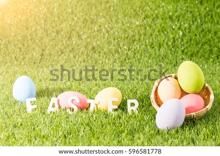 Easter bunny toy and Easter eggs on green grass with text with sunlight