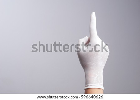 Hand wearing latex glove with number one index finger on white background