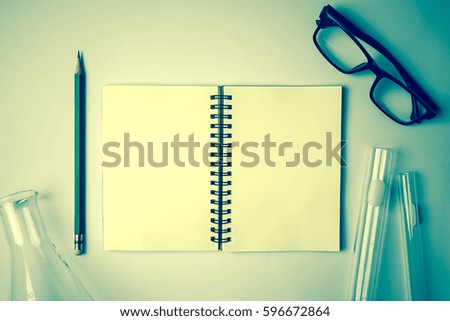 laboratory glasswares and blank notebook for background