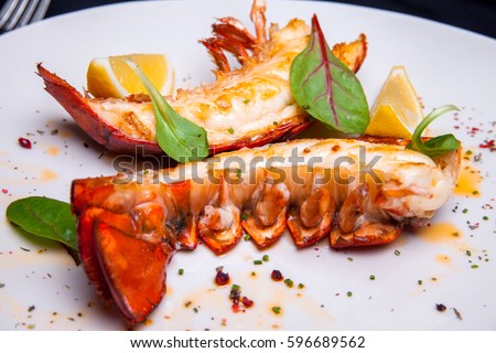 Lobster tail in maple-truffle sauce with lemon and basil Royalty-Free Stock Photo #596689562
