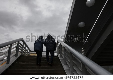 Senior Couple Walking Dachshund Dog Up Stairs