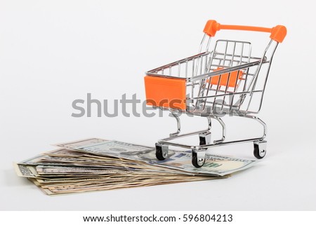 Shopping cart with dollars inside isolated on white
