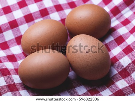 Eggs on red and white tablecloth. Horizontal shoot.